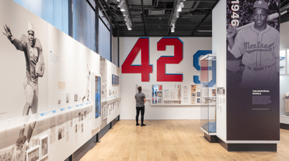 The inside of the Jackie Robinson Museum, featuring a man staring at memorabilia