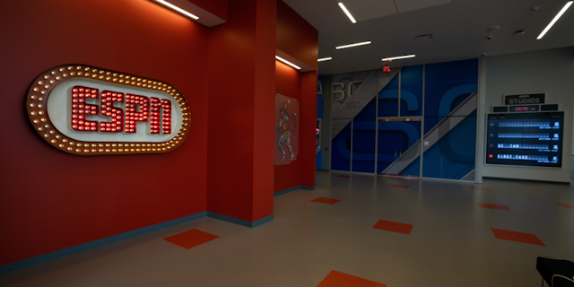Inside ESPN headquarters where there is a bright ESPN sign made of red and yellow light bulbs