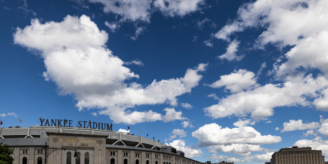 The exterior of Yankee Stadium™ with a vast partly cloudy sky above